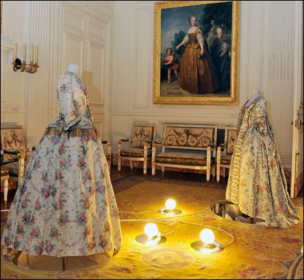 Left, gown à la française and skirt, circa 1750–1760; right, dress circa 1750–1753 in the Salon de la Chapelle, at Versailles